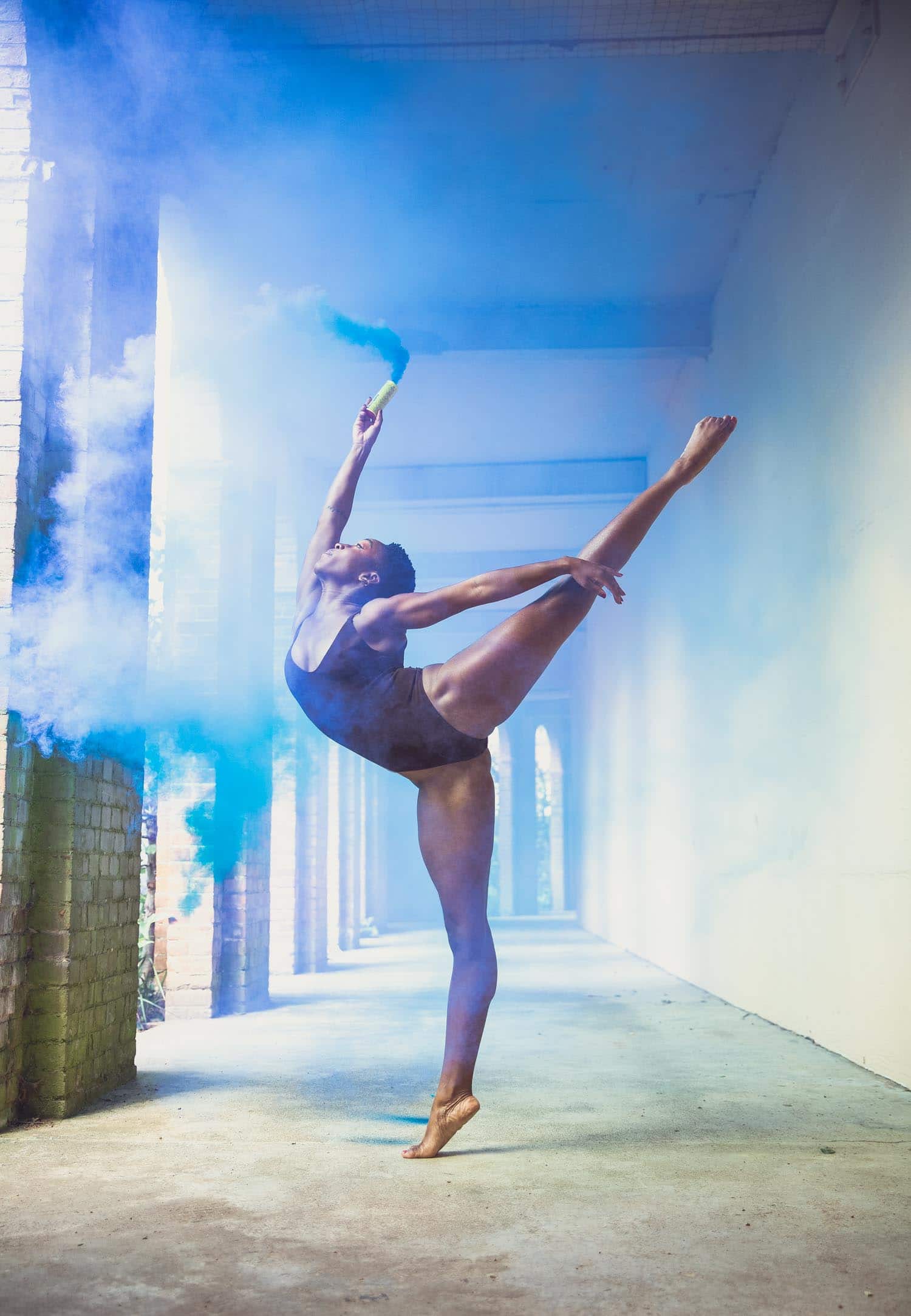 female dancer doing arabesque with smoke