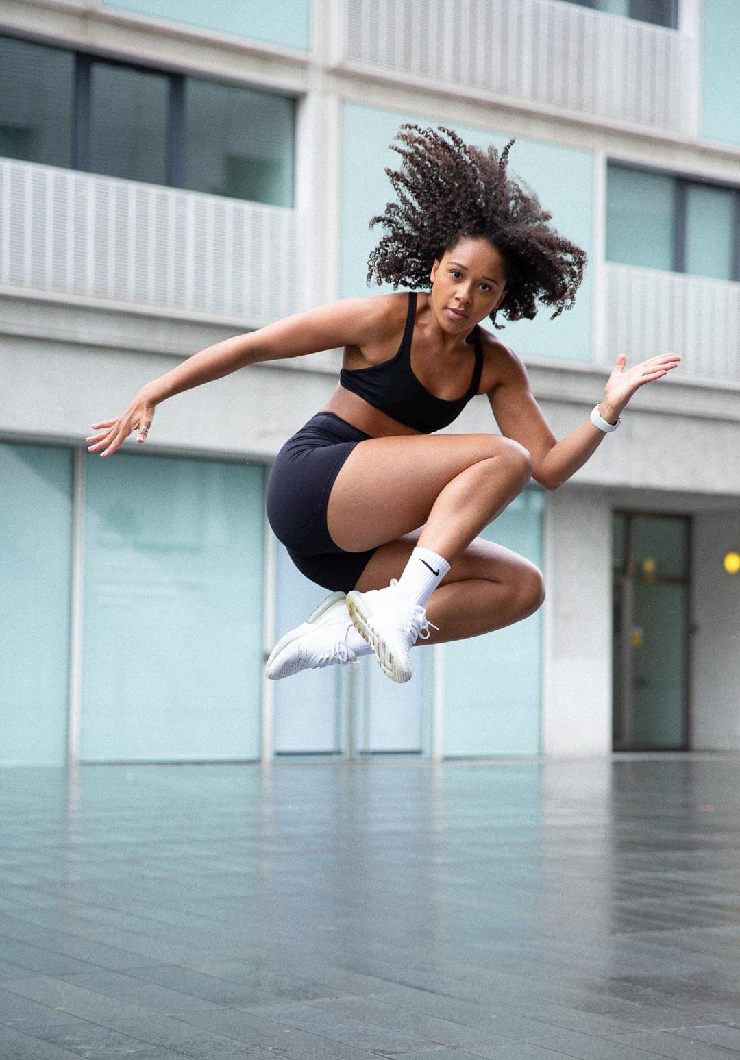 woman in fitness clothes and trainers jumping